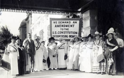 Members of the executive committee of the national suffragists’ convention and prominent local women supporting national political freedom for woman, snapped with Senator Reed Smoot outside the Hotel Utah, to whom they had just appealed for support of their movement in the next Congress. Image courtesy of National Women's Party
