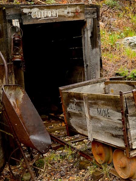 The remains of a mine and a railroad cutting through the side of a hill.