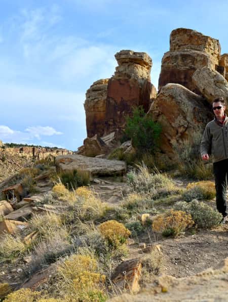 A man hiking on a trail in the desert during the day.