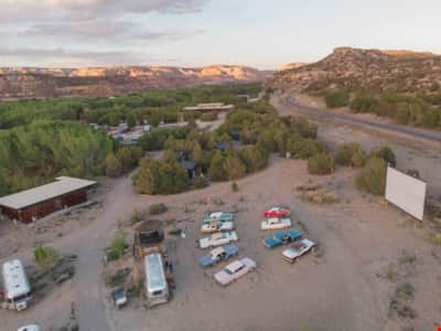 At Ofland Escalante, enjoy a drive-in experience in a pristine '57 Chevy or classic Ford Thunderbird, surrounded by towering red rock formations and an endless expanse of stars. 