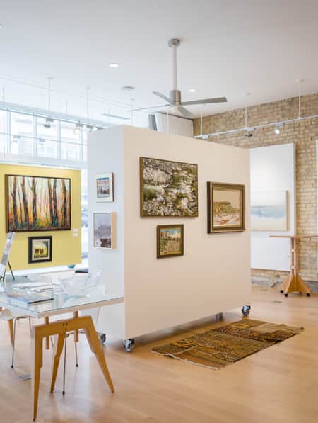 A gallery with abundant natural lighting showcasing art depicting nature scenes.