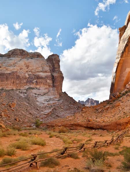 A small canyon of red rock with rocky fields on each side.